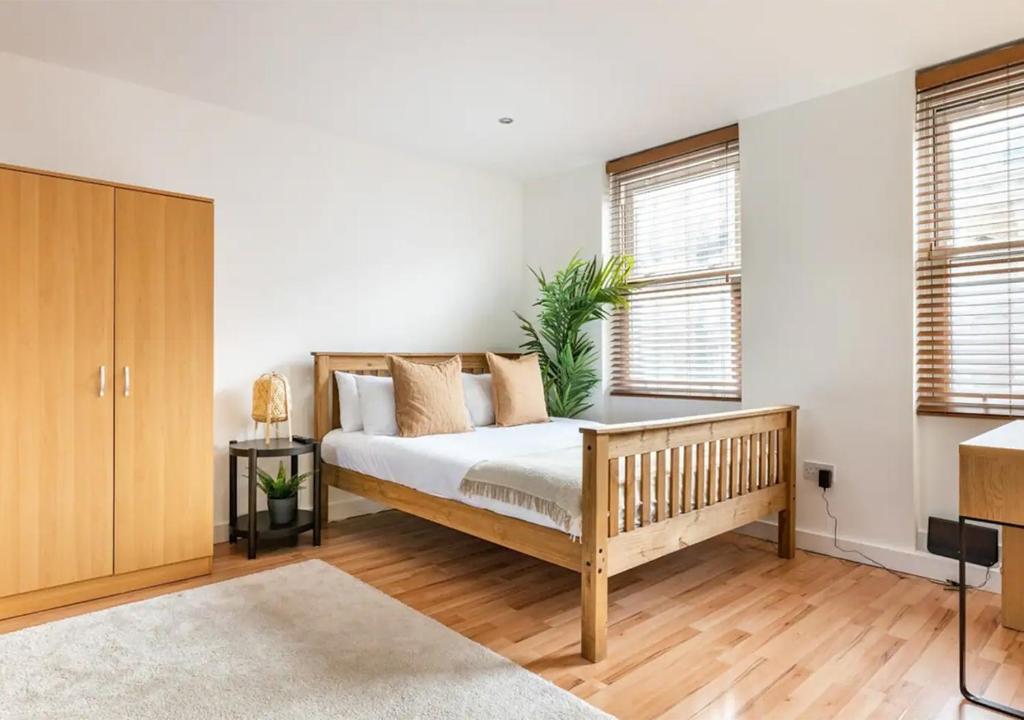 a bedroom with a bed and two windows at Modern Studio Apartment In Shoreditch in London