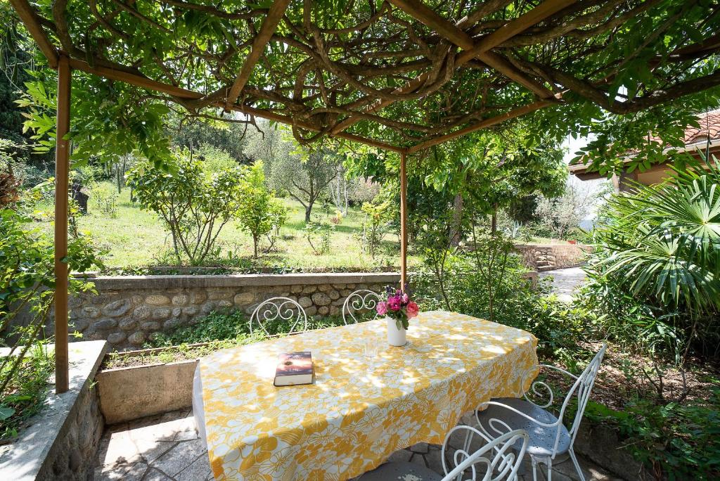 a table under an umbrella with a vase of flowers on it at Evasion Céret - Appt champêtre proche centre-ville in Céret