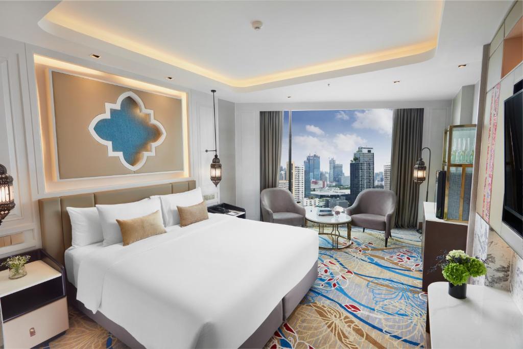 a hotel room with a large white bed and a large window at Valia Hotel Bangkok in Bangkok