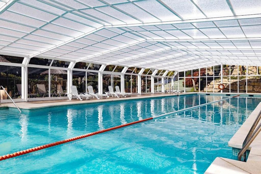 a large swimming pool with blue water in a building at 5* Serviced Apartment Marbella in Marbella