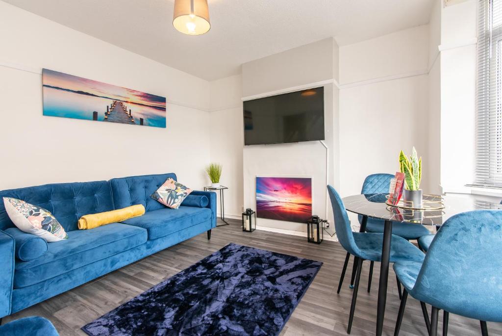 A home away from home - Derby في ديربي: غرفة معيشة مع أريكة زرقاء وطاولة