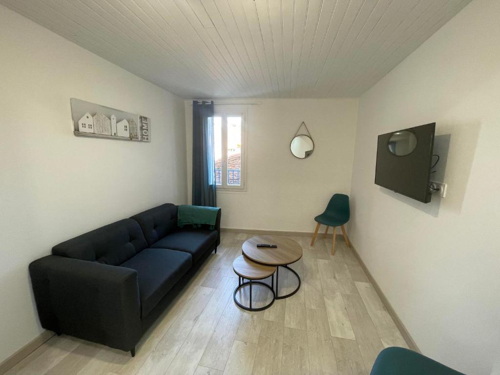 uma sala de estar com um sofá e uma mesa em 4TOAU11- Belle maison de village en plein cœur du Faubourg em Collioure