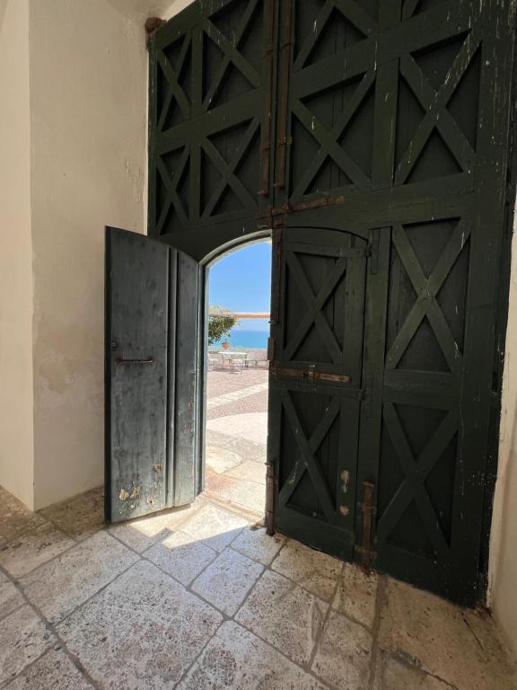 an open door in a building with a view of the ocean at Villa Basso Gargano in Monte SantʼAngelo