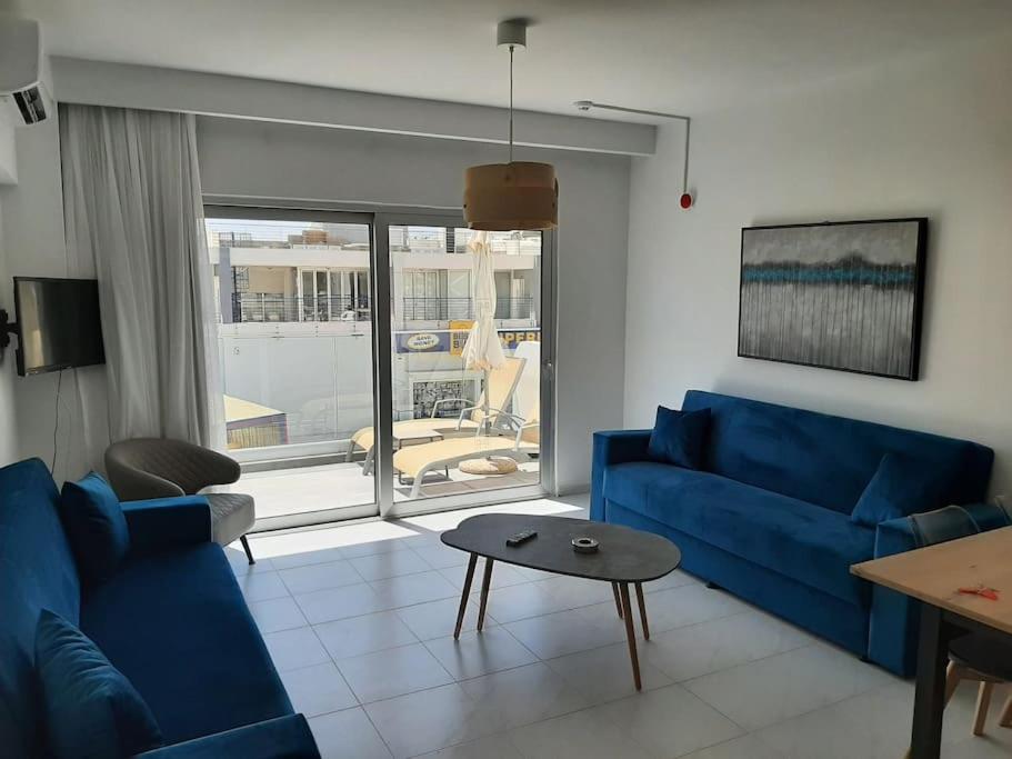 a living room with a blue couch and a table at Fig Tree Island Apartment-144 in Protaras