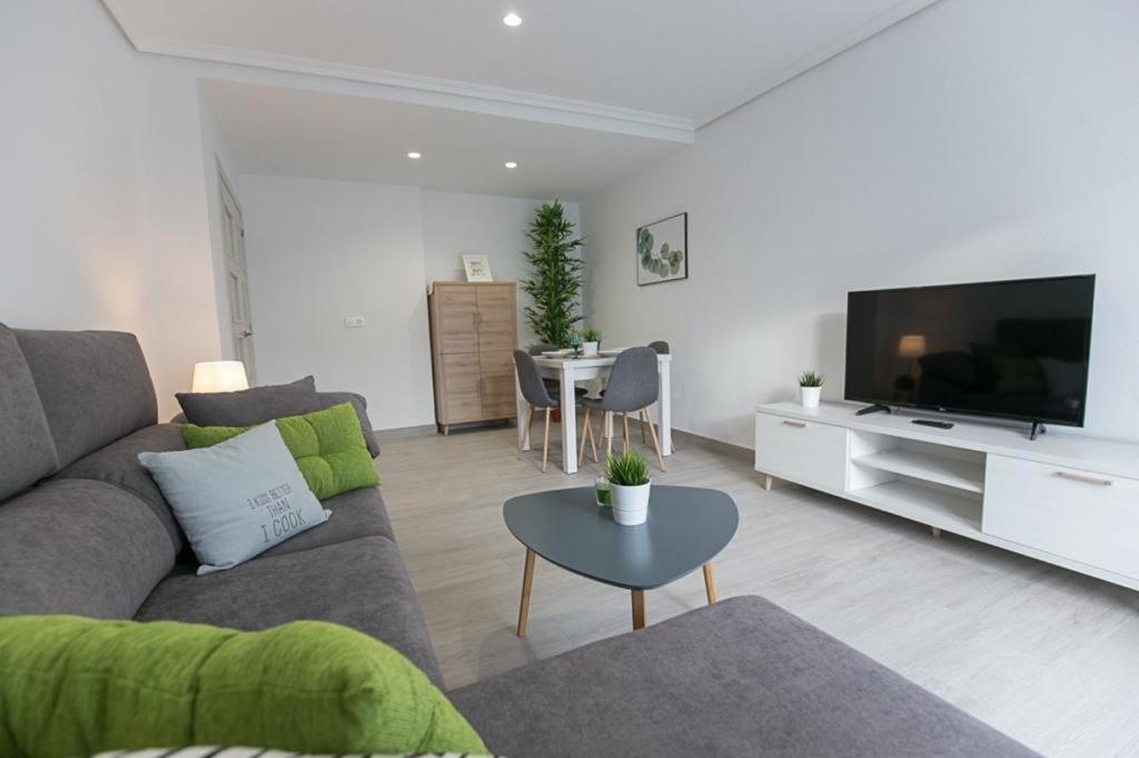 a living room with a couch and a tv and a table at Appartement entier in El Altet