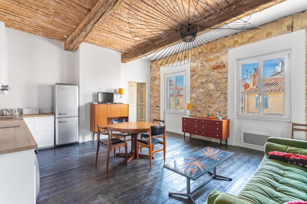 a kitchen and living room with a table and chairs at 70’s flat in Toulon