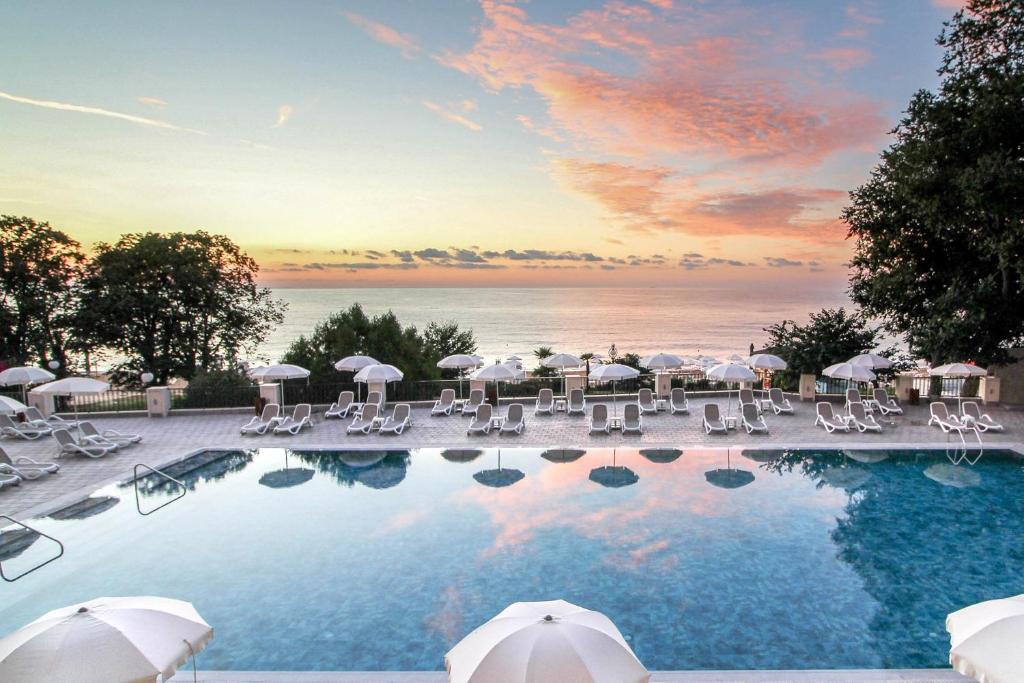 uma piscina com cadeiras e guarda-sóis e o oceano em GRIFID Vistamar Hotel - 24 Hours Ultra All inclusive & Private Beach em Golden Sands
