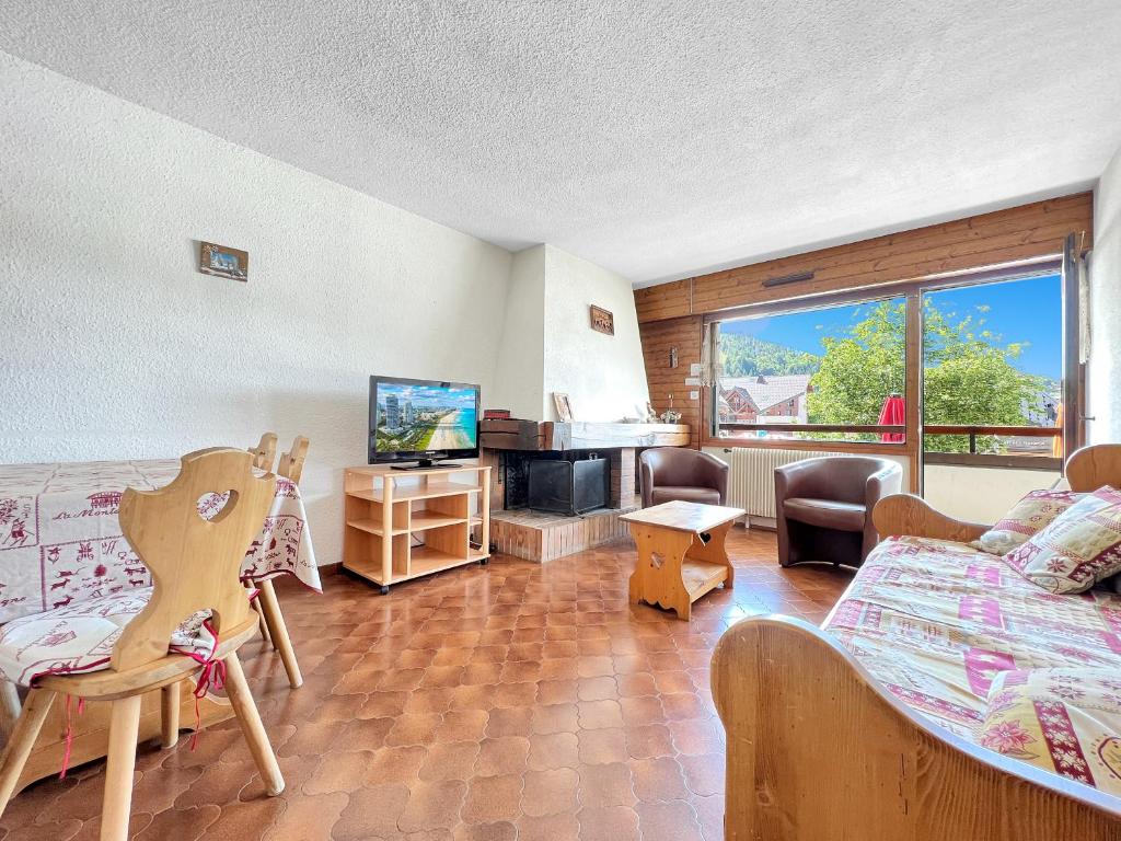 - un salon avec un lit, un canapé et une télévision dans l'établissement SL127 - 2 Pièces 4 Pers centre Carroz, aux Carroz d'Arâches