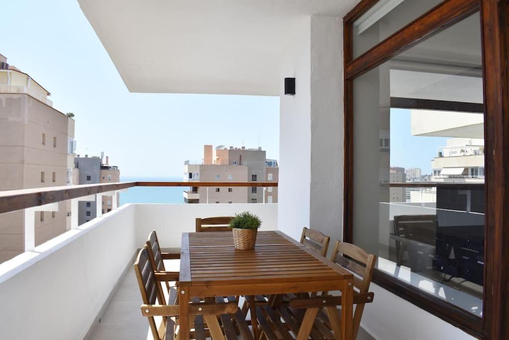 d'une table et de chaises en bois sur un balcon. dans l'établissement Mirador Torres de Playamar, con vistas al mar, à Torremolinos