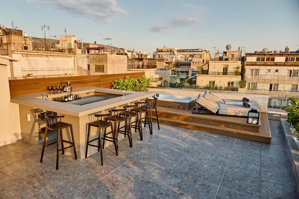 a bar on the roof of a building with a pool at Eclectic Acropolis Rooftop Loft in Athens