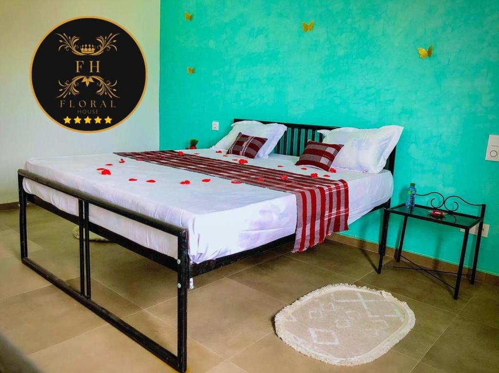 - un grand lit dans une chambre dotée d'un mur vert dans l'établissement MAISON FLORAL, à Saly Portudal