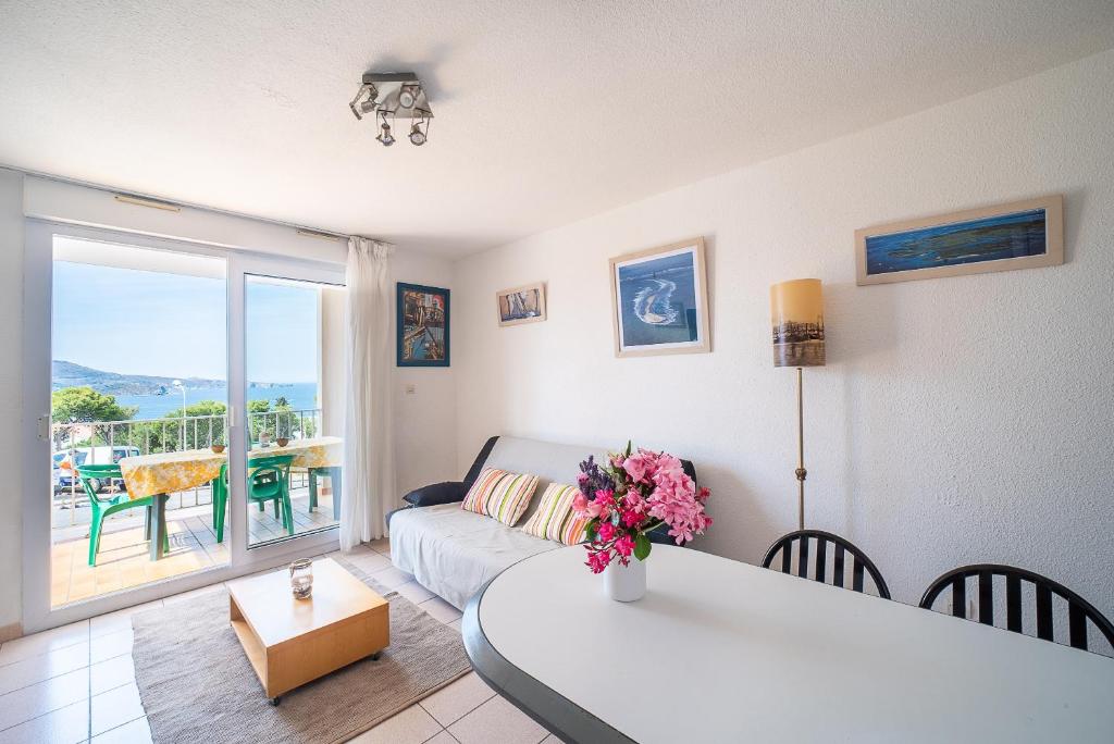 un salon avec un canapé et une table avec des fleurs dans l'établissement Evasion Banyuls - à 200m de la plage, à Banyuls-sur-Mer