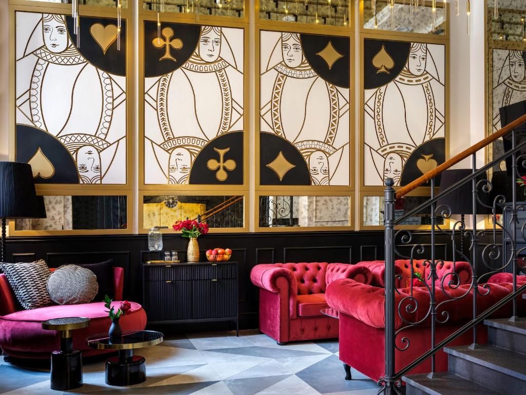 un vestíbulo con sofás rojos y una vidriera en Golden Queen Aparthotel en Cracovia