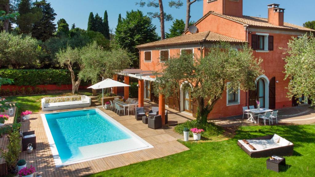 a house with a swimming pool in a yard at VILLA ROSSA 12, Emma Villas in Misano Adriatico