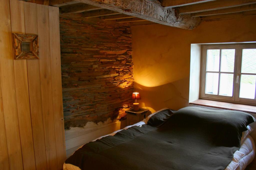 1 dormitorio con cama y ventana en La ferme Claudlisse, en Vielsalm