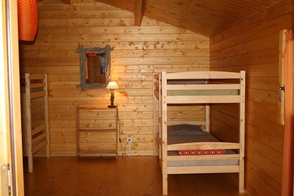 a room with two bunk beds in a log cabin at Auberge De La Foret Bonifatu in Calenzana