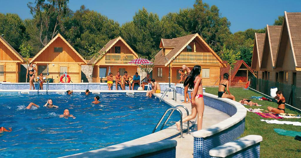 a group of people in a pool at a resort at Arc de Bará Camping & Bungalows in Roda de Bará