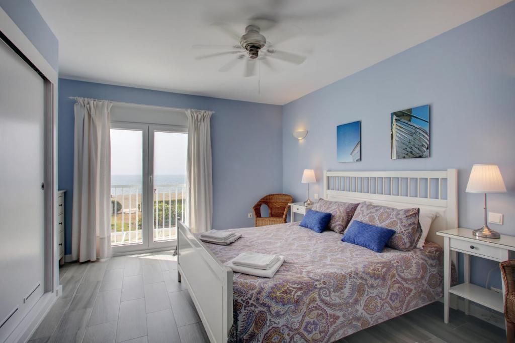 1 dormitorio con 1 cama y balcón en Your Vacation Retreat Right On The Beach, en Casares