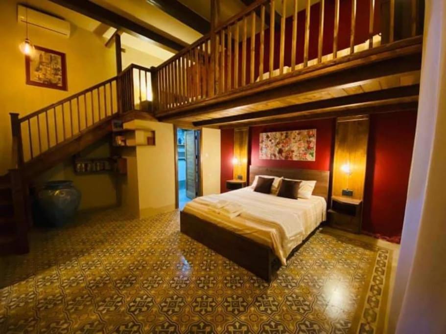 a bedroom with a large bed and a staircase at Ta' Ciangura House of Character in Għajnsielem