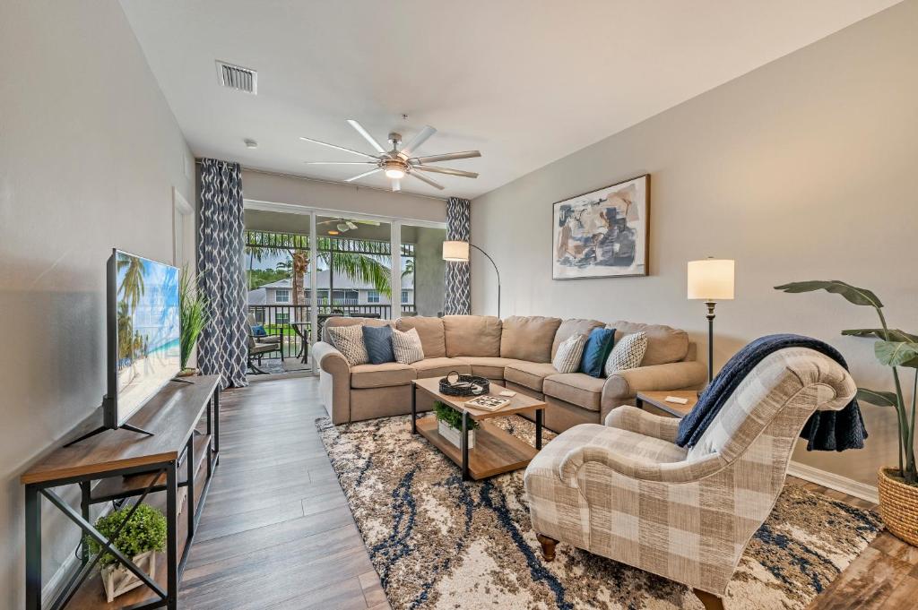 a living room with a couch and a tv at Golf Condo- Resort Pool- LakeView- 10mi to beaches in Naples