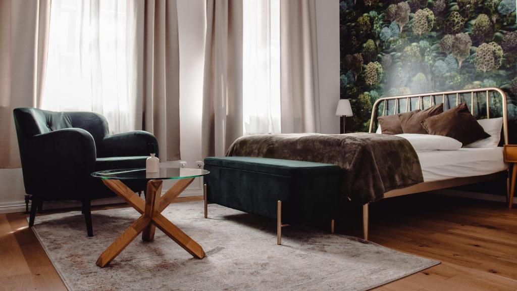 - une chambre avec un lit, un canapé et une table dans l'établissement Grâce Boutique Apartments, à Halle-sur-Saale