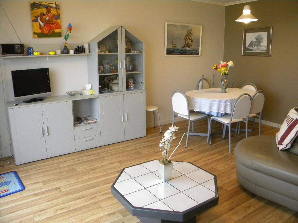 een woonkamer met een bank en een tafel bij Zandvlugge 0303 in Koksijde