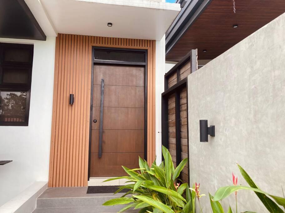 uma porta de madeira numa casa com algumas plantas em 4 Bedroom Villa near Clark (Casa Isabela) em Mabalacat