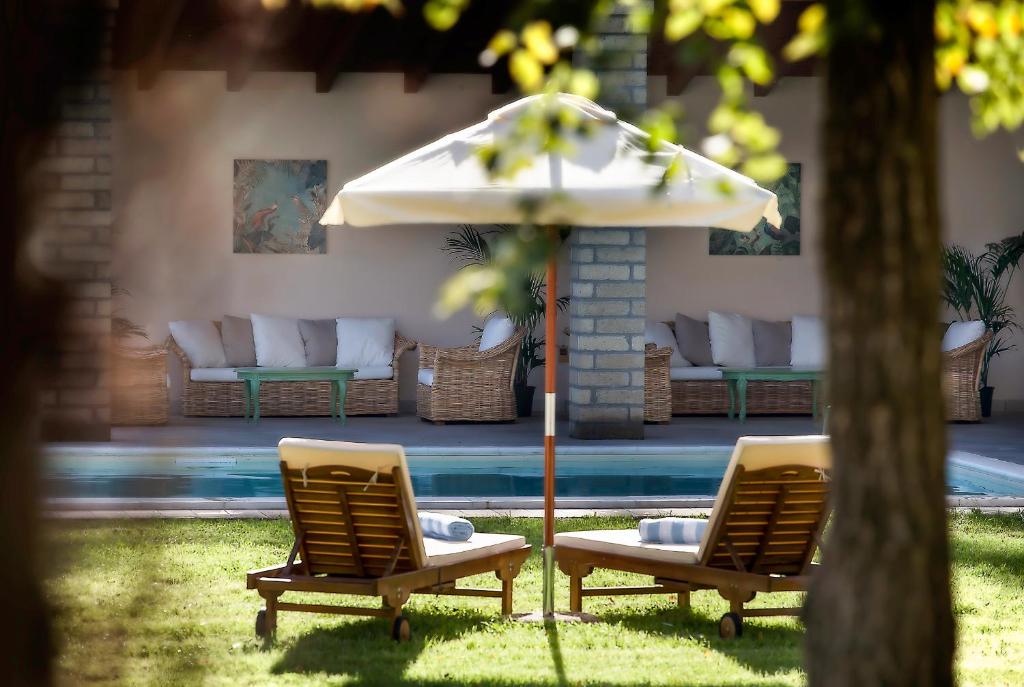 - deux chaises et un parasol à côté de la piscine dans l'établissement Poggio delle Molare Adults-Only Retreat, à Bracciano