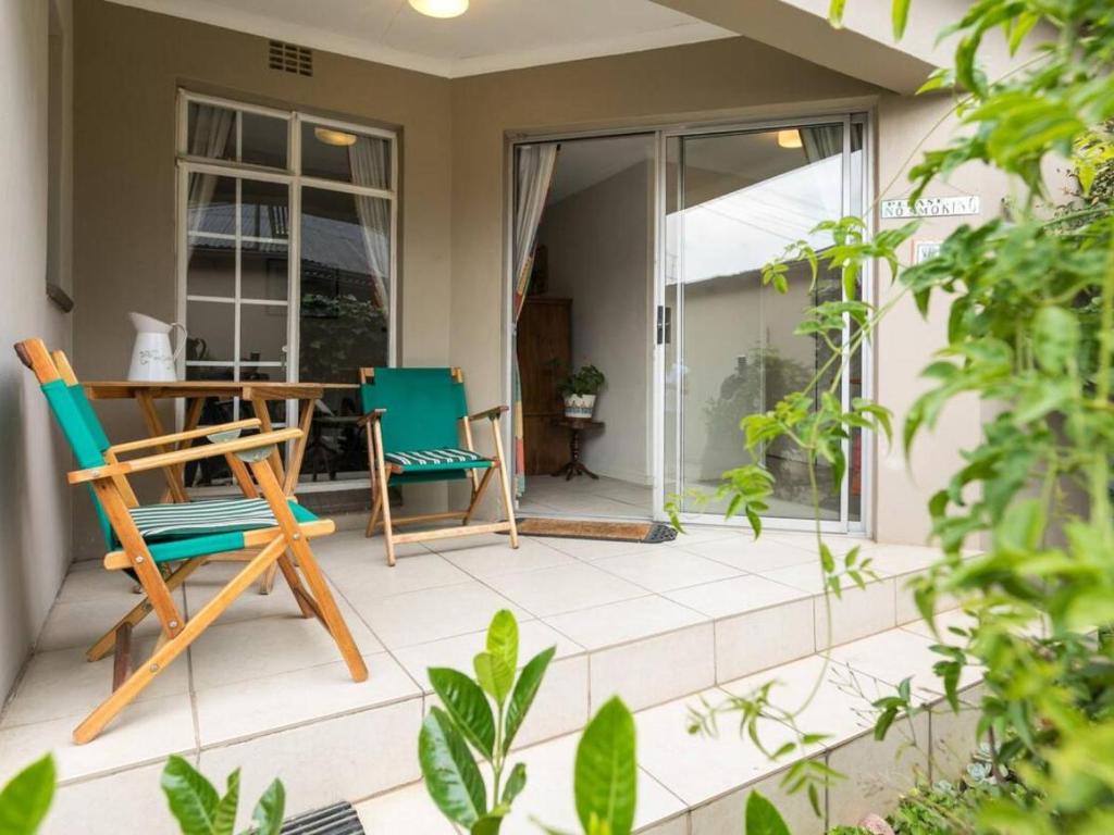eine Terrasse mit 2 Stühlen und einem Tisch in der Unterkunft Parkhurst Cottage in Johannesburg