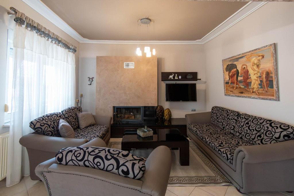 a living room with two couches and a tv at Vasiliana's Apartment in Alexandroupoli
