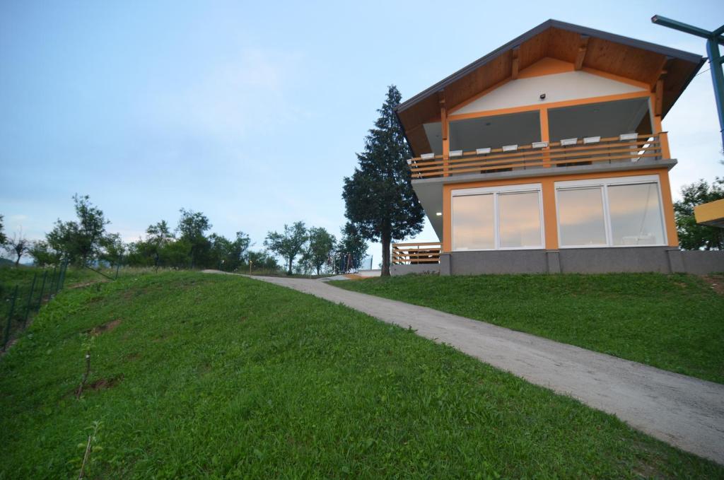 a house on a grassy hill with a pathway at vila sunset in Konjic