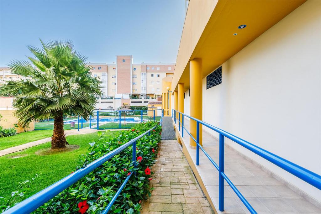 a balcony of a building with flowers and a palm tree at A&N Villa Catiana in Torre del Mar