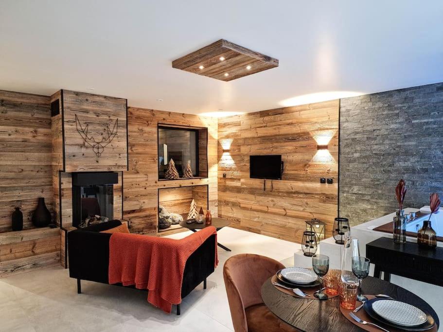 a living room with a fireplace and wooden walls at Le Enecy - Spa - Cœur Vieille ville in Annecy