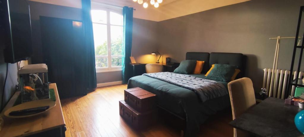 una camera con letto e finestra di Suite parentale avec grand bureau a Saint-Maur-des-Fossés