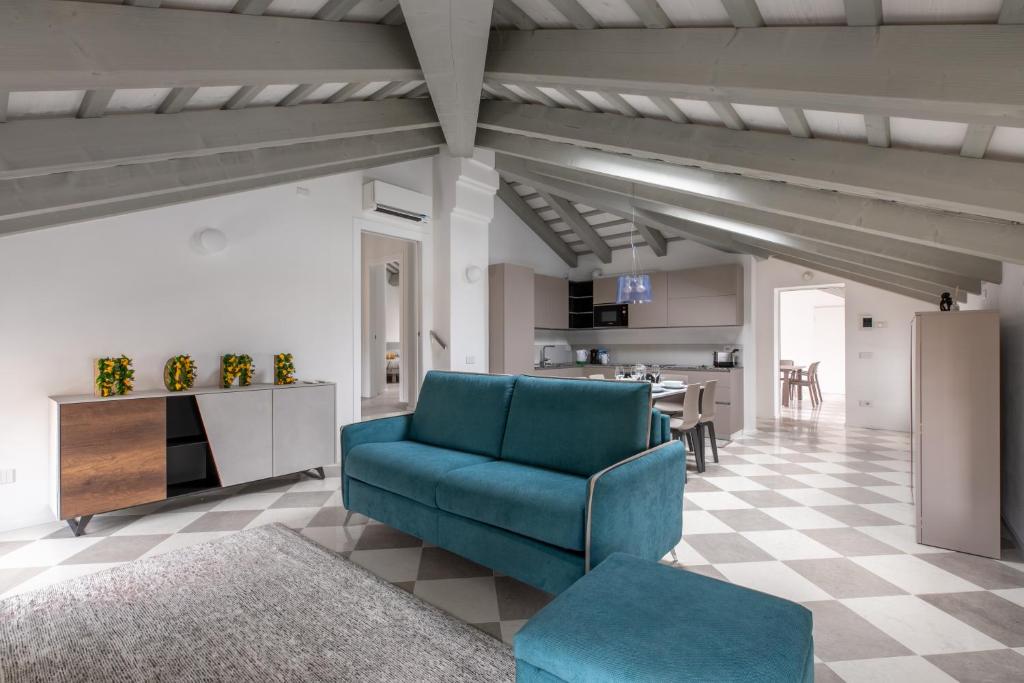 un soggiorno con divano blu e una cucina di Corte alle mura - Mansarda lux a Cittadella