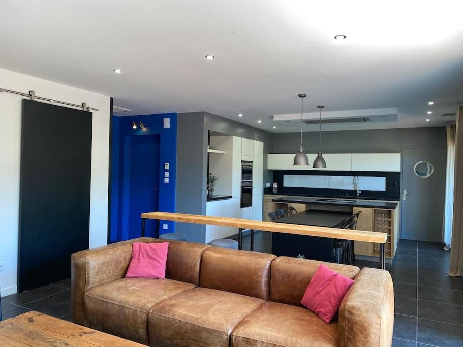 un salon avec un canapé marron et une table dans l'établissement CASA LUIS - Bel appartement avec piscine et proche de la mer, à Argelès-sur-Mer