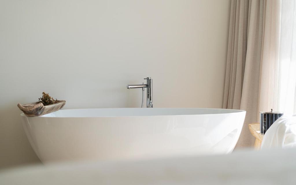 a white bath tub in a bathroom with a window at Amaria in Aljezur