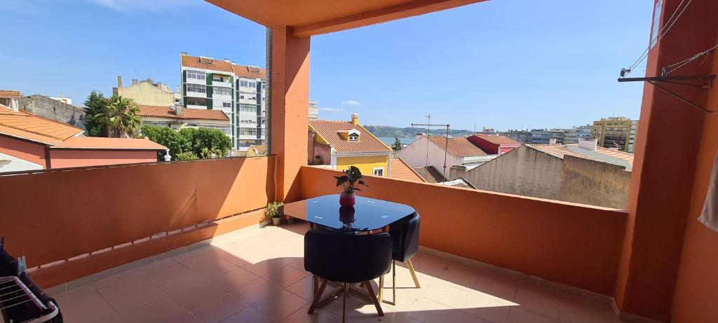 einen Balkon mit einem Tisch und Stadtblick in der Unterkunft Relax in Lisbon for 4 people with terrace and parking in Lissabon
