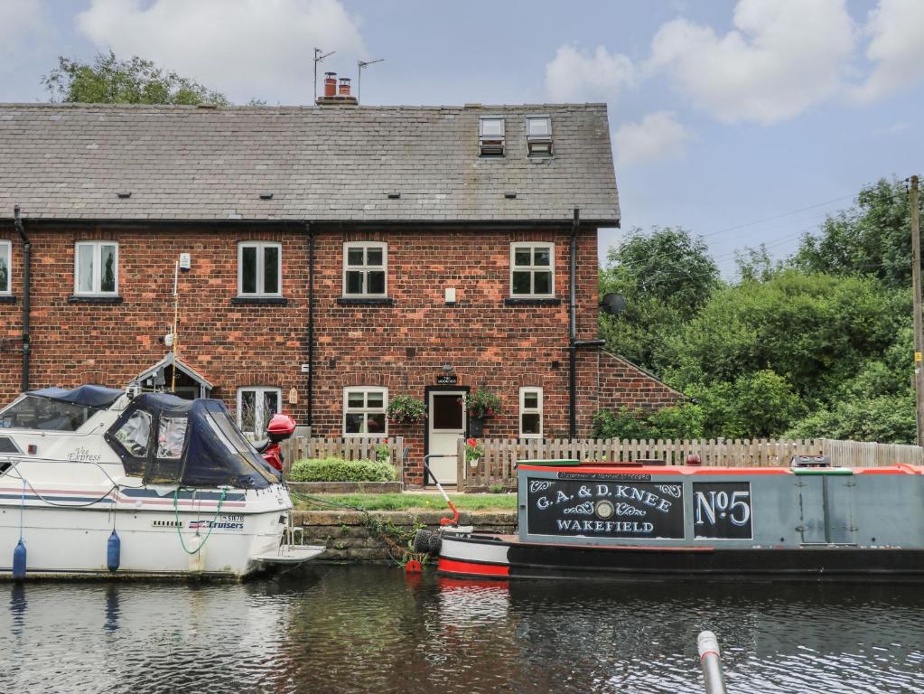 a boat is docked in front of a brick house at The Moorings in Wakefield