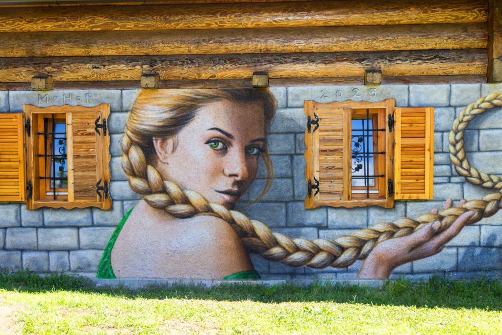 a mural of a woman on a wall with windows at Apartment in Chalet Goldilocks in Zgornje Gorje