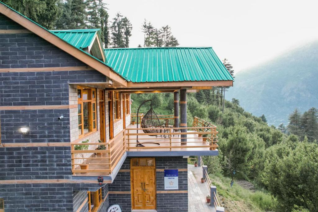 a house on the side of a mountain with a green roof at SaffronStays Kesar Villa, Manali - beautiful villa amidst an apple orchard - All clear roads in Manāli