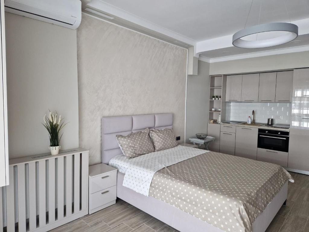 Il comprend une chambre blanche avec un lit et une cuisine. dans l'établissement Studio Casa del Mar, Mamaia Nord, cu vedere la mare & lac, à Mamaia