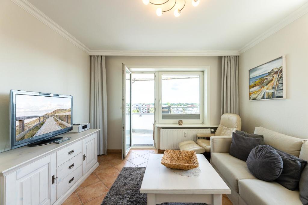een woonkamer met een bank en een tv bij Appartement Kleeblatt in Westerland