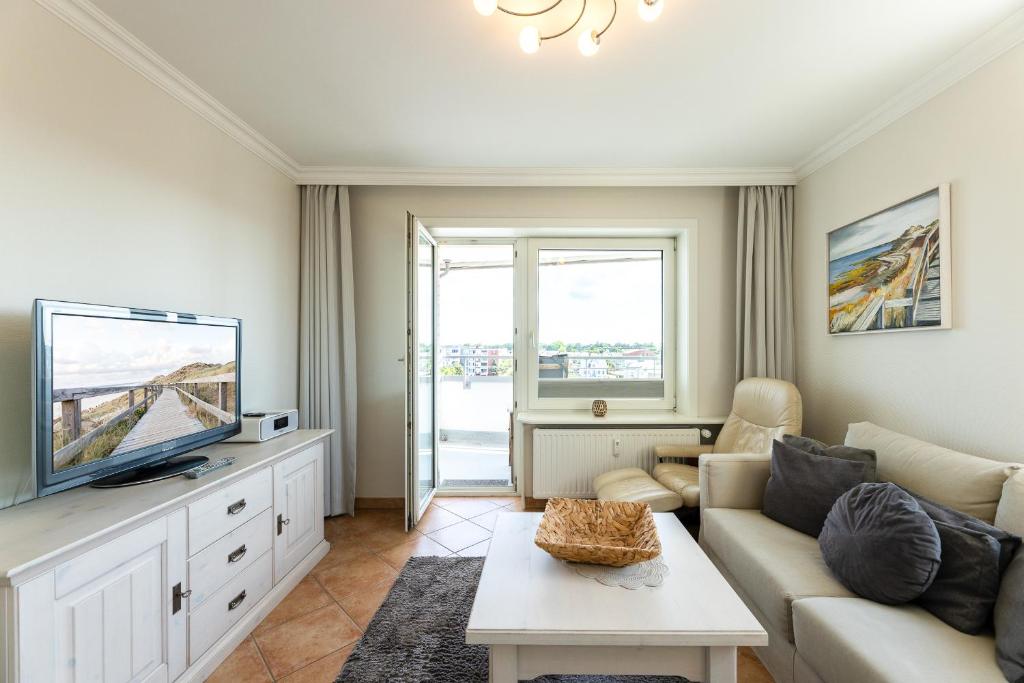 ein Wohnzimmer mit Couch und Fernseher in der Unterkunft Appartement Kleeblatt in Westerland