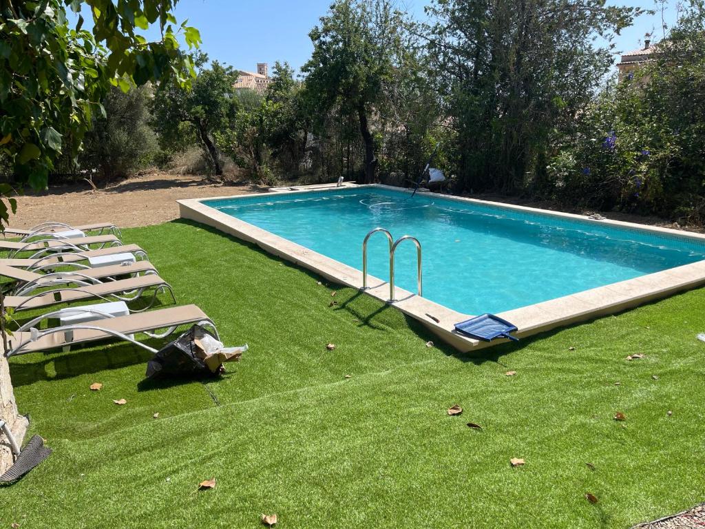 una gran piscina con sillas y un patio de césped en Tramuntana home with swimming pool, Can Canonge, en Selva