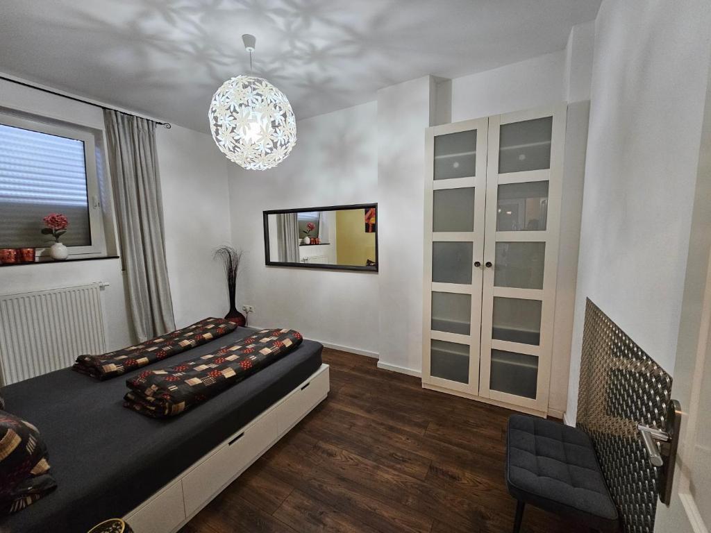 um quarto com uma cama e um lustre em Bismarck-Apartment em Kaiserslautern