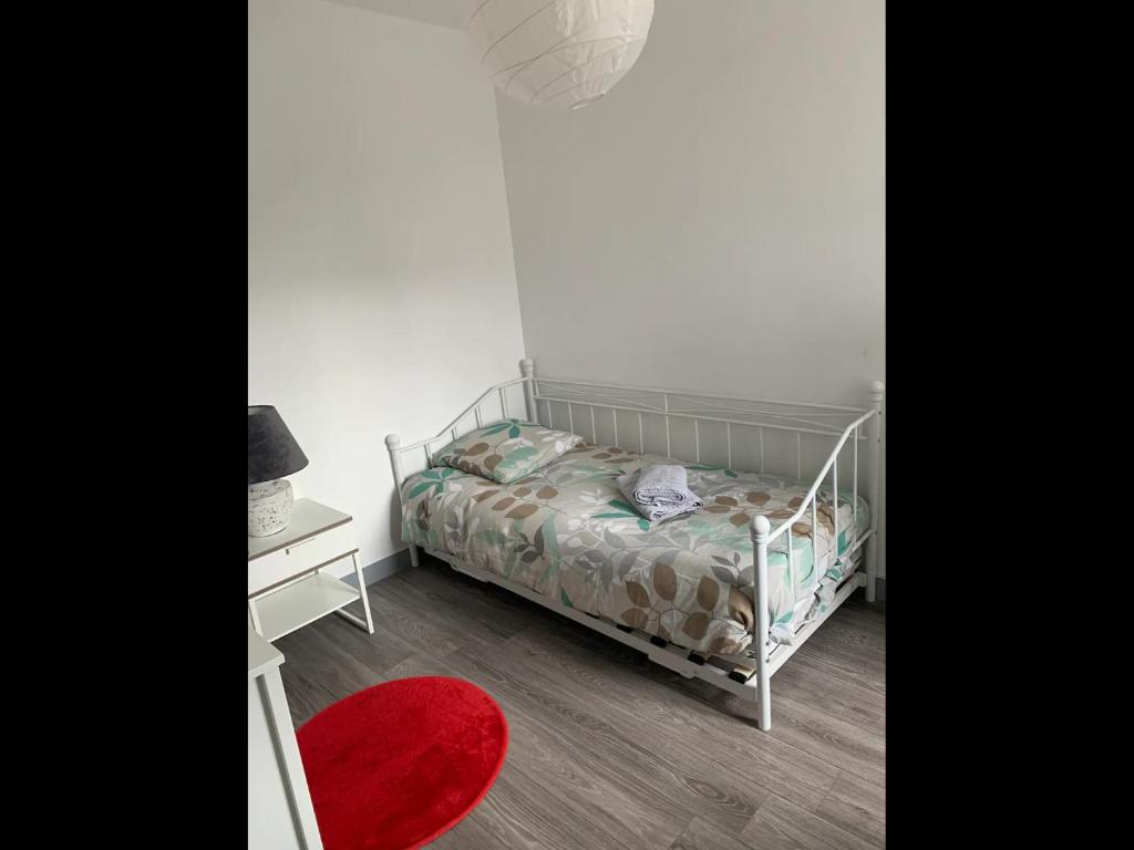 ein kleines Schlafzimmer mit einem Bett und einem roten Teppich in der Unterkunft Appartement en plein cœur de Brest in Brest