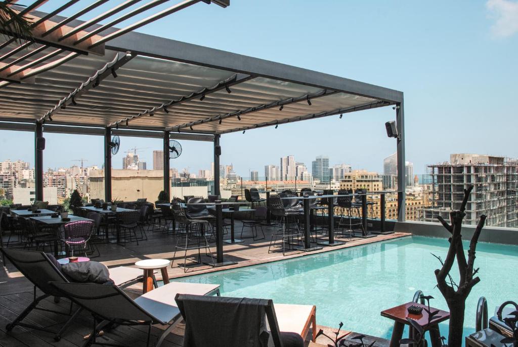 a rooftop patio with a pool and tables and chairs at O Monot Boutique Hotel Beirut in Beirut