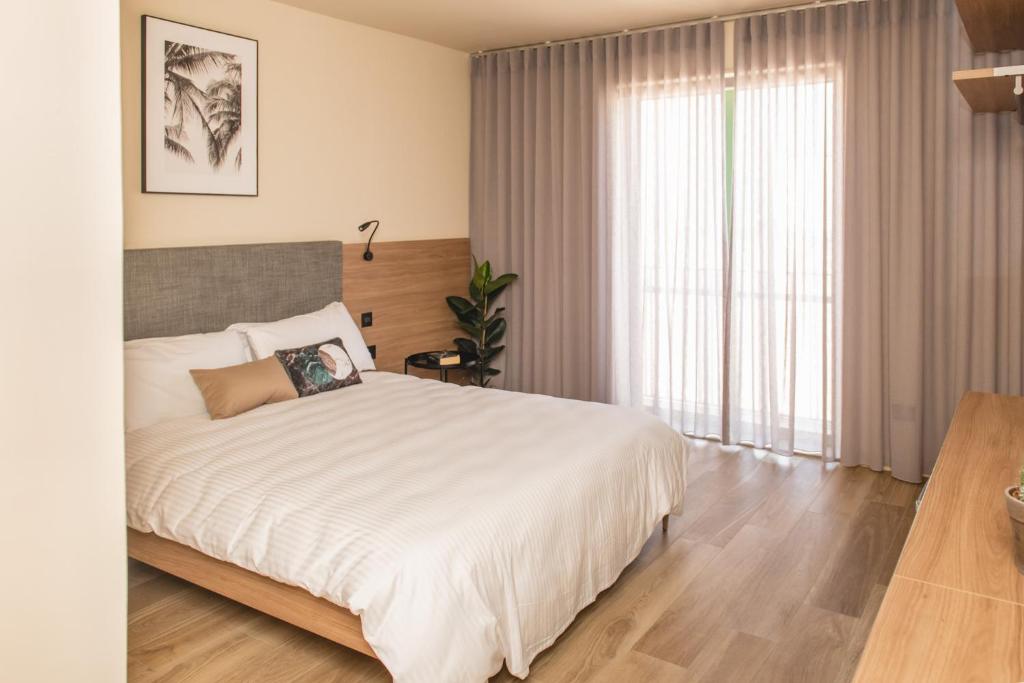 una camera con un grande letto e una grande finestra di Privilege Suit SLiema a Sliema