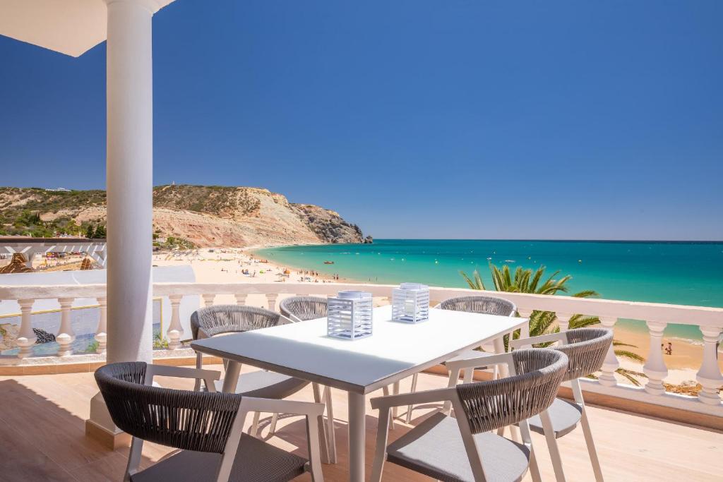 - Balcón con mesa y sillas y vistas a la playa en Beach View Apartment Praia da Luz by Blue Diamond, en Luz